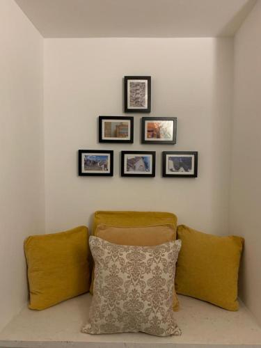 a room with four pictures on the wall and a pillow at Trullidea in Alberobello