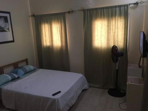 a bedroom with a bed and two windows with curtains at Dakar Top destination in Dakar