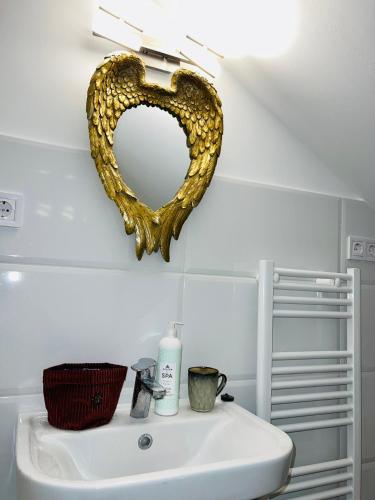 a mirror on the wall above a bathroom sink at Balcsitthon Apartmanok in Siófok