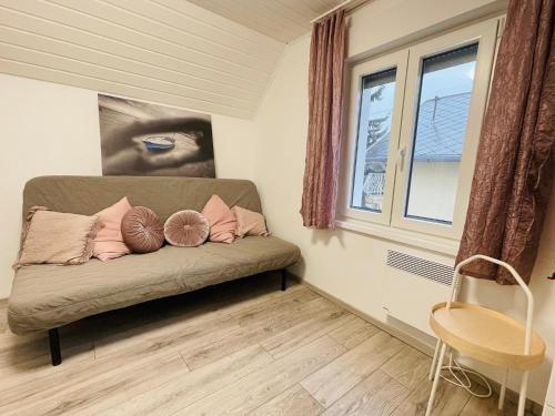 a couch with two pillows on it in a room at Balcsitthon Apartmanok in Siófok