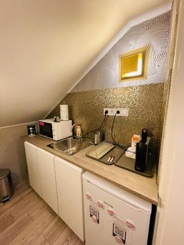 a kitchen with a sink and a counter top at Balcsitthon Apartmanok in Siófok