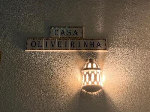 a light hanging on a wall with a street sign at Casa Oliveirinha - Sagres in Sagres