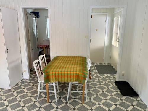 a room with a table with chairs and a checkerboard floor at Fjällnära Stuga i Jämtland in Svenstavik