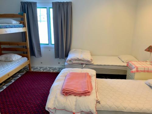 a room with three bunk beds and a red carpet at Fjällnära Stuga i Jämtland in Svenstavik