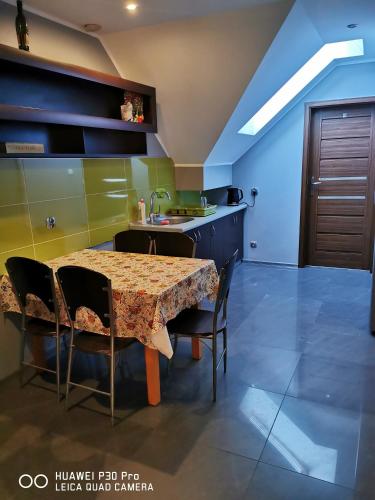 a kitchen with a table and chairs and a sink at Noclegi Mazur przysiersk in Przysiersk