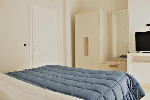 a bedroom with a blue blanket on a bed at Zibibbo Beach Apartments - Trapani in Trapani