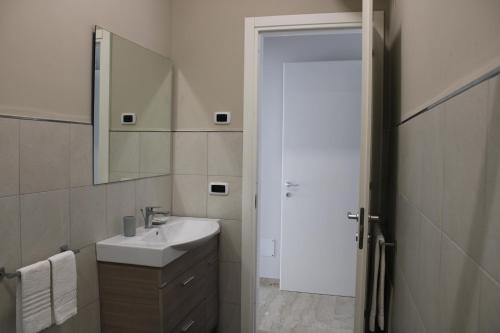 a white bathroom with a sink and a mirror at Zibibbo Beach Apartments - Trapani in Trapani