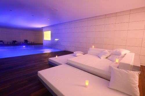 a living room with two white beds and candles at Finca Prats Hotel Golf & Spa in Lleida