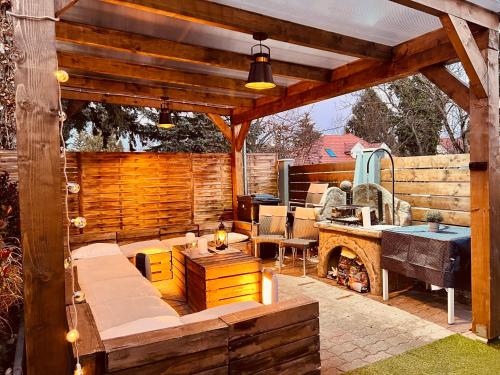 an outdoor patio with a wooden pergola at Balcsitthon Apartmanok in Siófok