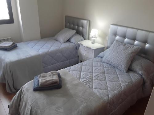1 dormitorio con 2 camas y mesita de noche en Apartamento de 6 personas con WIFI Y GARAJE INCLUIDO en Valladolid
