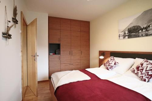 a bedroom with a large bed and a wooden cabinet at Haus Schmied in Weissensee