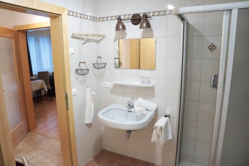 a white bathroom with a sink and a shower at Haus Schmied in Weissensee