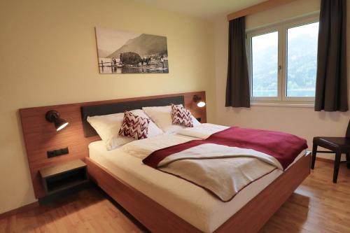 a bed in a bedroom with a large window at Haus Schmied in Weissensee