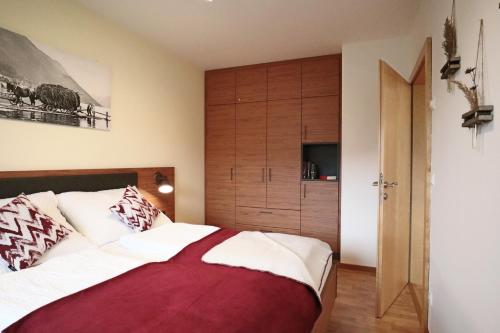 a bedroom with a bed and a large wooden cabinet at Haus Schmied in Weissensee