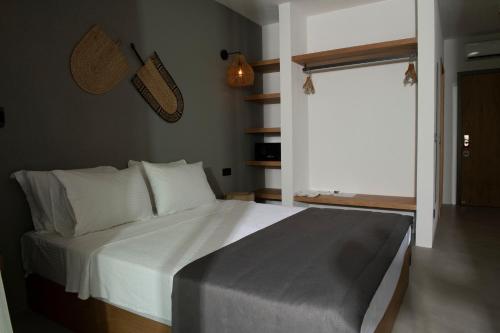 a bedroom with a bed with white sheets and a window at Regia Mare Beach Hotel & Spa Bodrum in Ortakent
