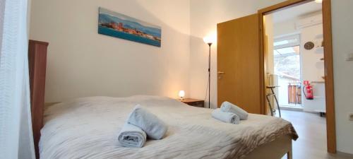 a bedroom with a bed with two pillows on it at Apartma Gušt Koper in Koper