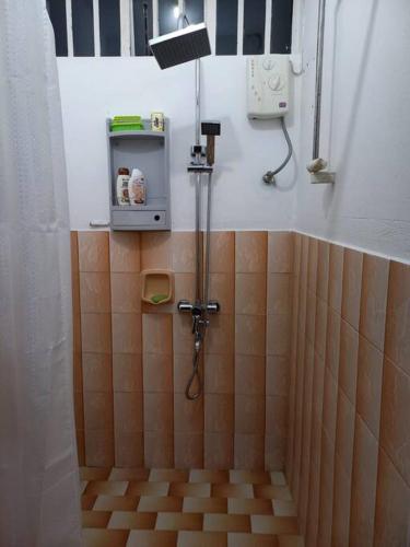 a bathroom with a shower with brown tiled walls at Vacances Le Nereide Blue Bay in Blue Bay