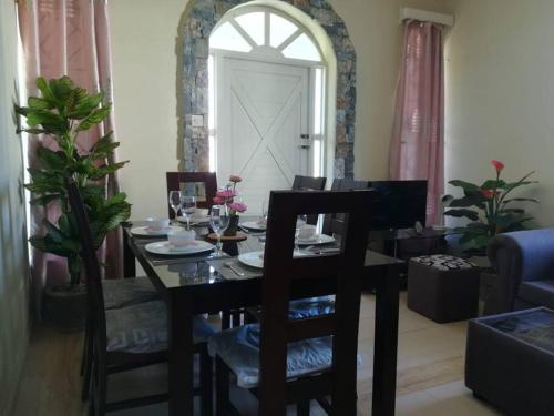 a dining table and chairs in a living room at Vacances Le Nereide Blue Bay in Blue Bay