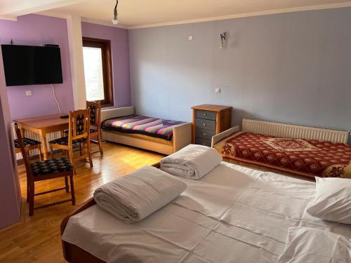 una camera con 2 letti, un tavolo e una scrivania di Apartments and Rooms Vicko a Brzeće