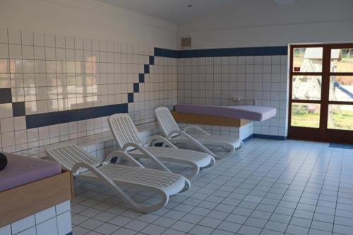 a bathroom with four chairs and two sinks at FitApartman in Mitterfirmiansreut