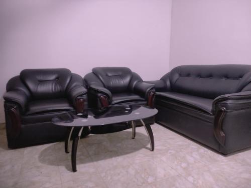 two black leather couches and a table in a room at Deer Garden Guest in Polonnaruwa