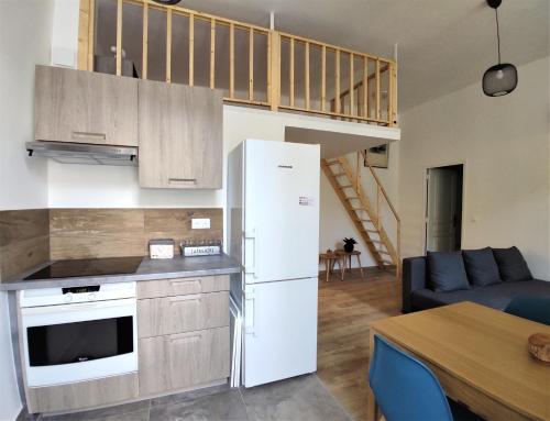 une cuisine avec un réfrigérateur blanc et une table dans l'établissement 2 à 6 personnes - WELCOME TO NICE ! LOGEMENT PORT, à Nice