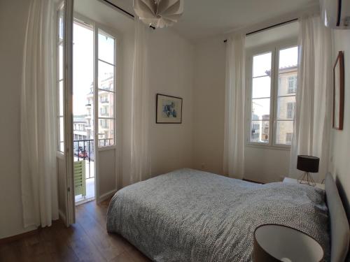 une chambre avec un lit et deux fenêtres dans l'établissement 2 à 6 personnes - WELCOME TO NICE ! LOGEMENT PORT, à Nice