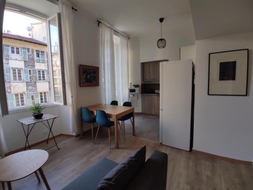 un salon avec une table et un réfrigérateur dans l'établissement 2 à 6 personnes - WELCOME TO NICE ! LOGEMENT PORT, à Nice