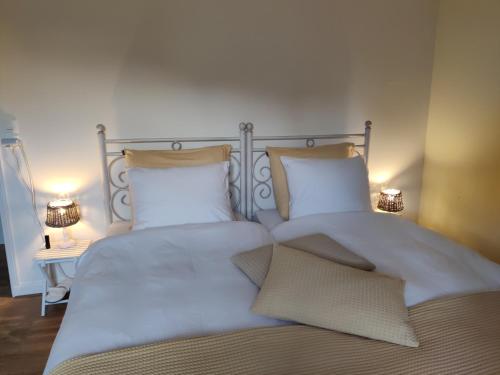 a bedroom with two beds with white sheets and pillows at Chambres d'hôtes / B&B Chez Mon Rêve in Éguzon-Chantôme