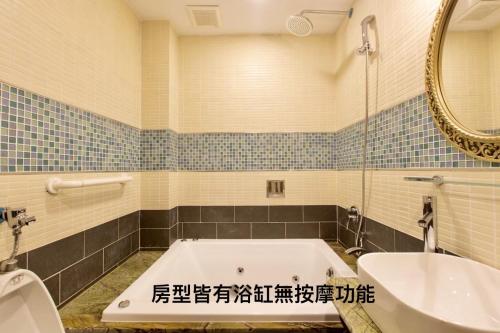 a bathroom with a tub and a sink and a mirror at Puli Story House in Puli