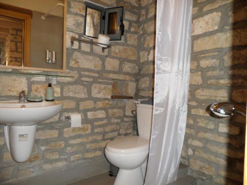 uma casa de banho com um WC e um lavatório em Kalpaki stone apartment 1 em Kalpákion