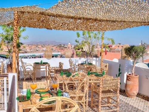 un patio con tavoli, sedie e vista sulla città di Riad Art & Emotions Boutique Hotel & Spa a Marrakech
