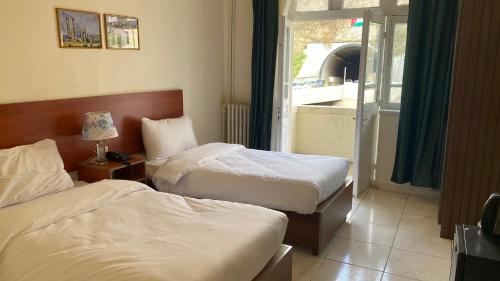 a hotel room with two beds and a window at New Park Hotel in Amman
