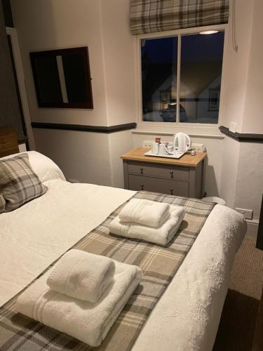 a bedroom with a bed with towels on it at The Royal Oak Inn in Bowness-on-Windermere