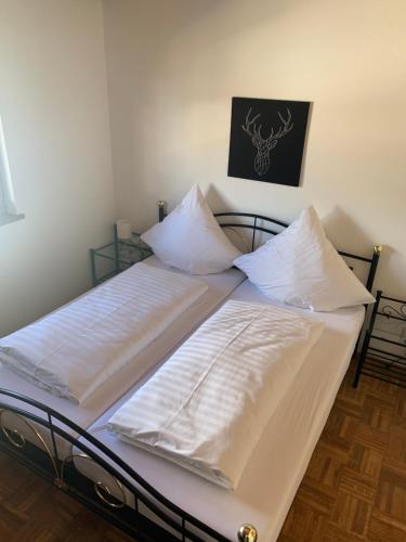 a bed with white sheets and pillows on it at Ferienwohnung Maier Schliersee Neuhaus in Schliersee