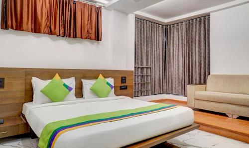 um quarto com uma cama grande e uma cadeira em Hotel Shivas Inn em Colhapur