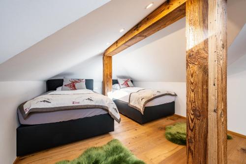two beds in a attic bedroom with a mirror at Villa Ambach in Oetz