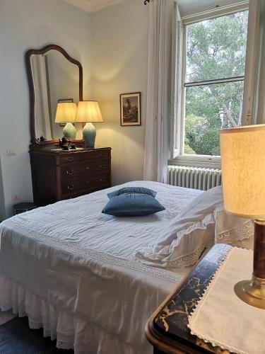 a bedroom with a bed with a mirror and a window at Villa Monacelli in Fano