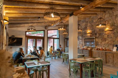 a group of people sitting at tables in a restaurant at Ecohotel Posta de Purmamarca in Purmamarca