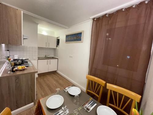 een kleine keuken met een tafel en een eetkamer bij Kolossos Apartments zum Sporthafen Neuss in Neuss