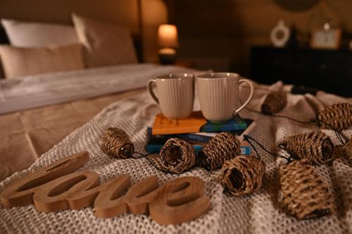 a table with two cups and some cookies on it at Domes Town by ANGAR in Vahagnadzor