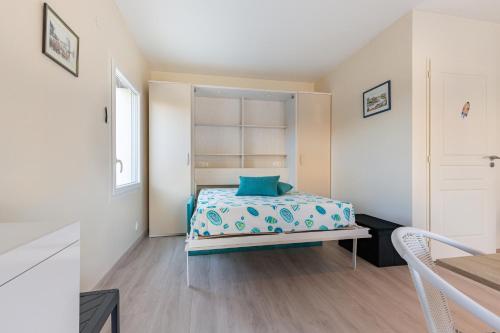 Un dormitorio con una cama con una almohada azul encima. en Manava, en Vaux-sur-Mer