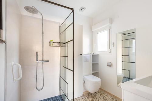 a white bathroom with a shower and a toilet at Manava in Vaux-sur-Mer