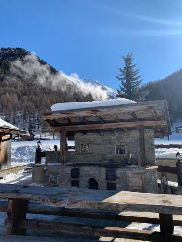 a stone fireplace with snow on top of it at Chalet in Via Dali Mina in Livigno