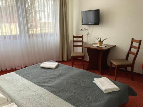 a hotel room with a bed and a table and chairs at Yacht Club Residence Sopot in Sopot