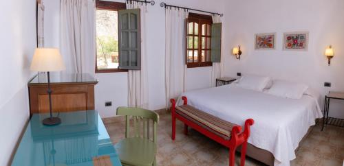 1 dormitorio con cama, mesa y ventana en Posta de Purmamarca en Purmamarca