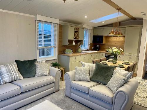 a living room with two couches and a kitchen at 5 Lake View, Barrow, Clitheroe - in the heart of the Ribble Valley in Pendleton