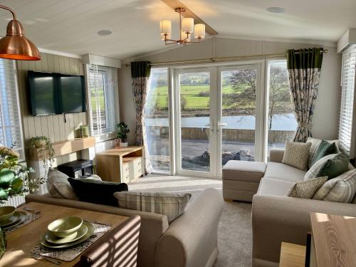 ein Wohnzimmer mit einem Sofa und einem Tisch in der Unterkunft 5 Lake View, Barrow, Clitheroe - in the heart of the Ribble Valley in Pendleton