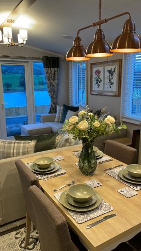 a dining room table with a vase of flowers on it at 5 Lake View, Barrow, Clitheroe - in the heart of the Ribble Valley in Pendleton