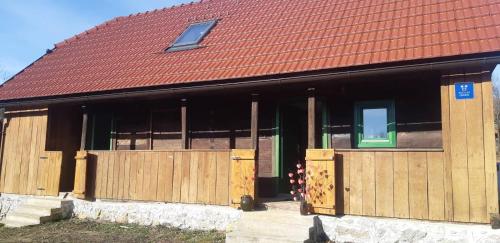 a building with wooden doors and a red roof at Bakina iža in Duga Resa